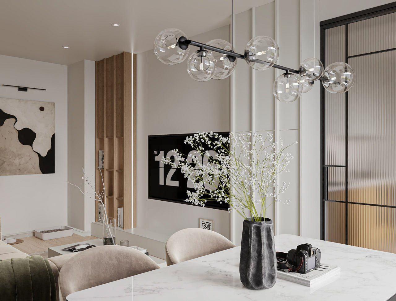 Dining table under a line of clear glass pendants, looking toward the living-room media wall and the fluted-glass partition.